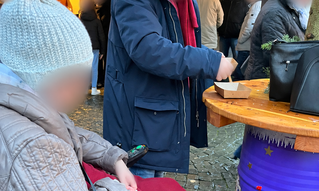 Besuch auf dem Weihnachtsmarkt mit Rollstuhl und Hund.